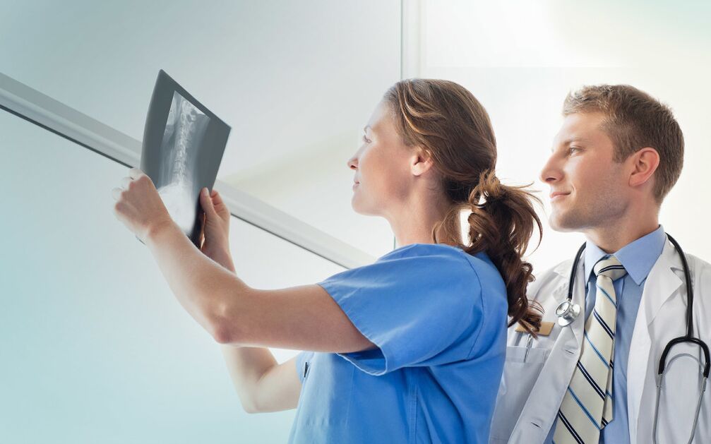médicos que miran unha radiografía para detectar a artrose